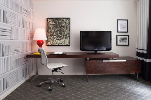a room with a desk with a chair and a television at The Fifty Sonesta Hotel New York in New York