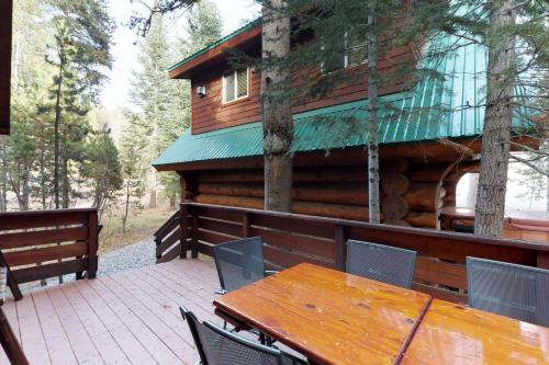 a wooden table and chairs on the deck of a cabin at Loggers Landing in Lakeshore