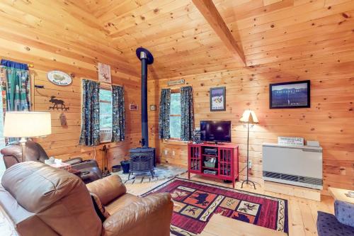 a living room with a couch and a television in a cabin at Maine Attraction in Upper Shirley Corner