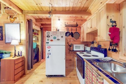 a white refrigerator in a kitchen with wooden cabinets at Maine Attraction in Upper Shirley Corner
