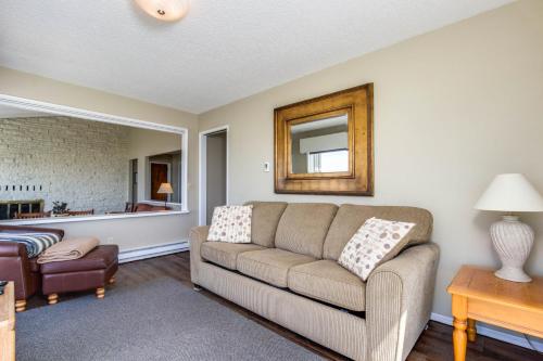 a living room with a couch and a mirror at Spindrift Oceanfront Home - The Helm in Bandon