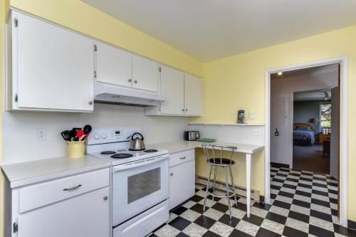 a kitchen with white cabinets and a black and white checkered floor at Spindrift Oceanfront Home - The Helm in Bandon