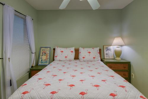 a bedroom with a bed with pink birds on it at Phoenix Seabird in Romar Beach