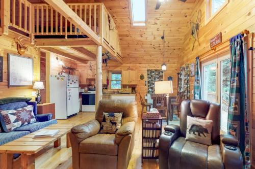 a living room with leather furniture in a log cabin at Maine Attraction in Upper Shirley Corner