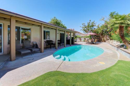 a swimming pool in a yard next to a house at Buttercup Delight Permit# 106,312 in Bermuda Dunes