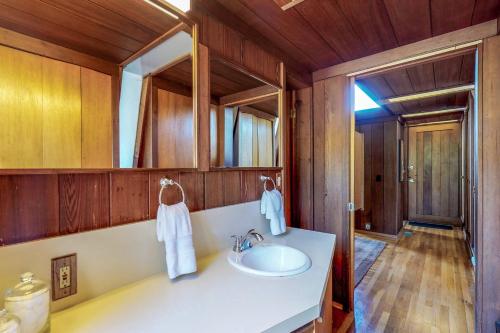 La salle de bains est pourvue d'un lavabo blanc et de murs en bois. dans l'établissement Elk Mid-Century, à Elk