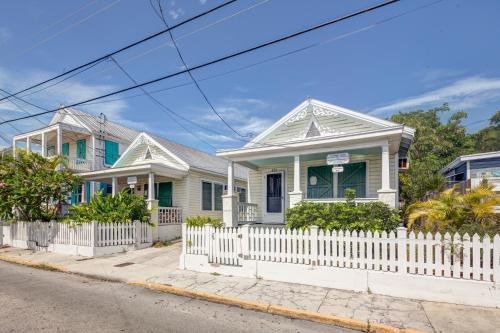 a white picket fence in front of two houses at Windward Isle in Key West
