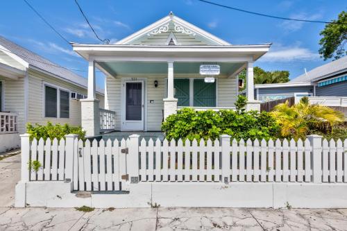 a white picket fence in front of a white house at Windward Isle in Key West