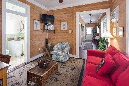 a living room with a red couch and a chair at Leeward Isle in Key West