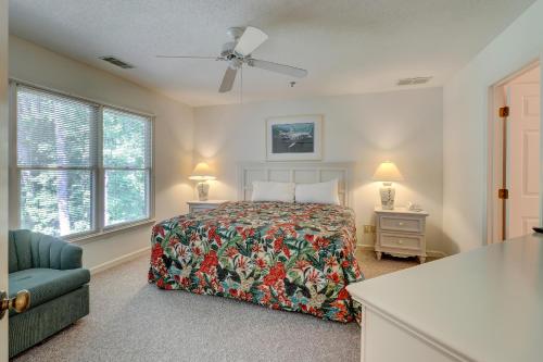 Schlafzimmer mit einem Bett, einem Stuhl und Fenstern in der Unterkunft Ocean Breeze 96 in Hilton Head Island