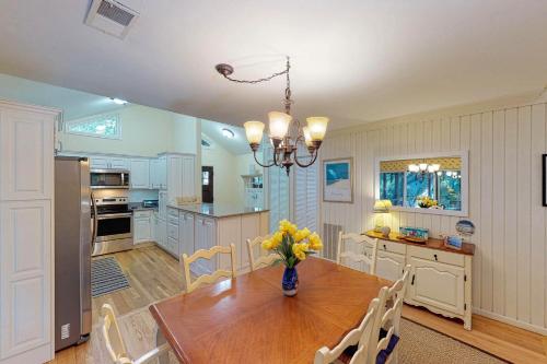 a kitchen with a wooden table with a vase of flowers on it at Oceanwoods 443 in Kiawah Island