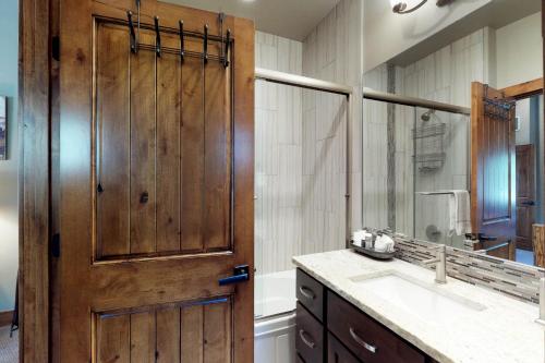 a bathroom with a wooden door and a sink at Tamarack Cottage in Donnelly