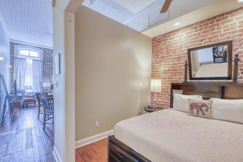 a bedroom with a brick wall and a bed with a mirror at Savannah Serendipity in Savannah