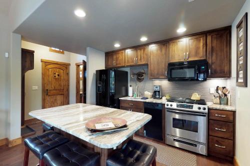 a kitchen with wooden cabinets and a table and a stove at Tamarack Cottage in Donnelly