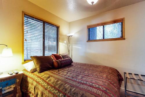a bedroom with a bed and two windows at The Cottage in Shaver Lake
