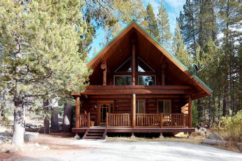 a log cabin in the woods with a tree at Loggers Landing in Lakeshore