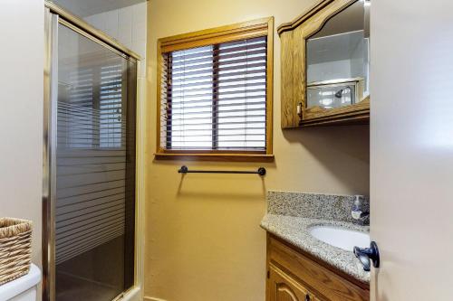 baño con lavabo, ducha y ventana en The Cottage en Shaver Lake