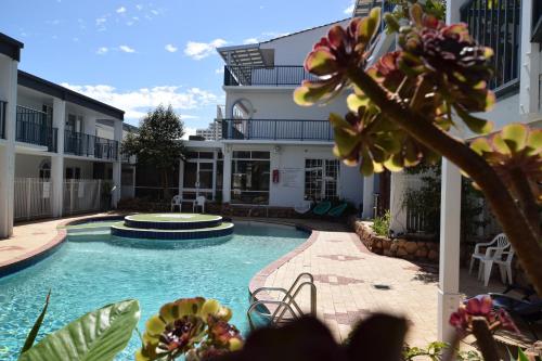 
a patio with a pool and lawn chairs at West Beach Lagoon 109 – Amazing Location! in Perth
