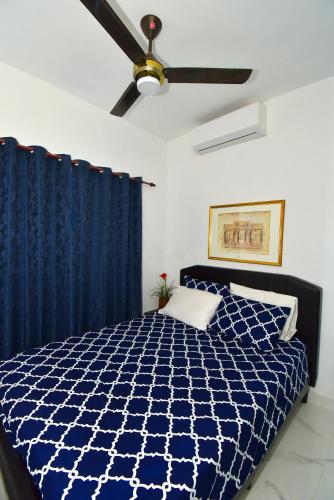 a bedroom with a blue bed and a ceiling fan at Rosil Place in San Felipe de Puerto Plata