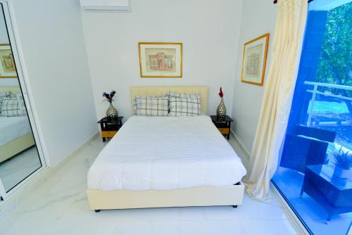 a bedroom with a bed and a large window at Rosil Place in San Felipe de Puerto Plata