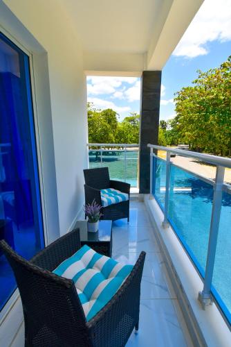 a balcony with two chairs and a table at Rosil Place in San Felipe de Puerto Plata