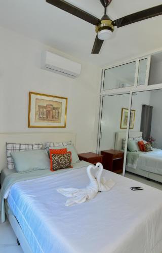 a bedroom with a white bed with a swan on it at Rosil Place in San Felipe de Puerto Plata