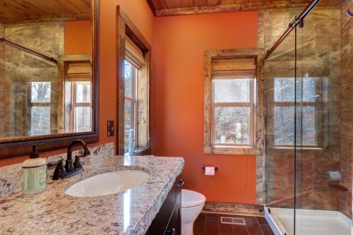 y baño con paredes de color naranja, lavabo y ducha. en Ned's Norris Nook, en Maynardville