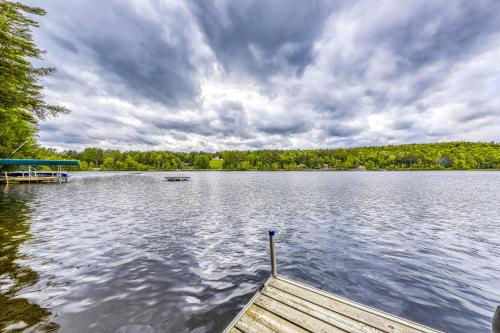 a dock on a lake with a boat on it at Basic Adirondack Camp in Chestertown