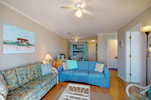 a living room with a blue couch and a ceiling fan at Best Beach Spot in Myrtle Beach