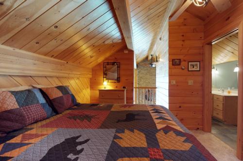 um quarto com uma cama num chalé de madeira em Lodge at Moosehead Lake em Greenville Junction