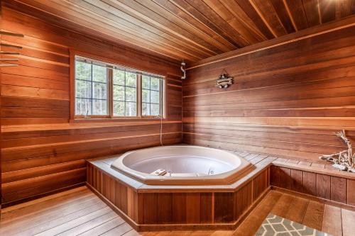 bañera en una habitación de madera con ventana en Hidden Village 724, en Big Sky