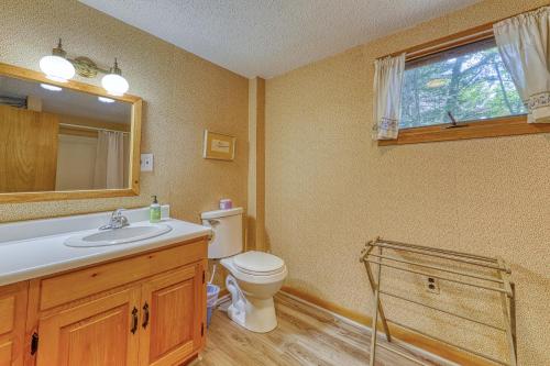 a bathroom with a toilet and a sink and a mirror at 30 Pauli Point Road in Freedom