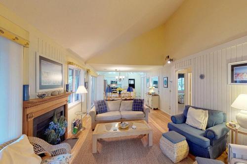 a living room with blue chairs and a fireplace at Oceanwoods 443 in Kiawah Island