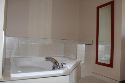 a white bath tub with a sink and a mirror at Quality Inn Southampton in Southampton