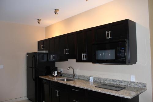a kitchen with black cabinets and a sink and a microwave at Quality Inn Southampton in Southampton