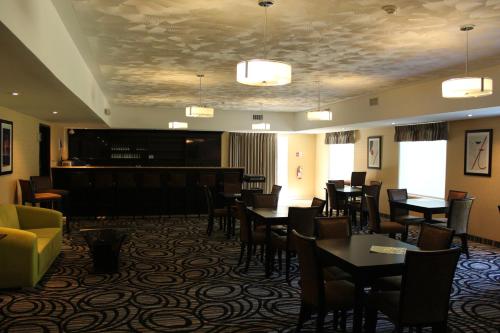 um restaurante com mesas e cadeiras e um bar em Quality Inn Southampton em Southampton