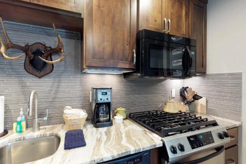 a kitchen with a stove and a microwave at Tamarack Cottage in Donnelly