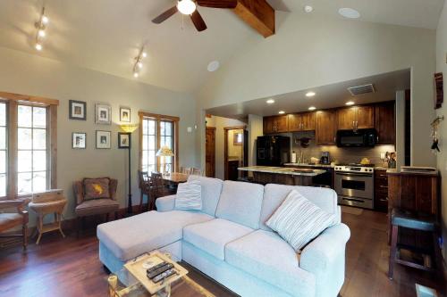 a living room with a couch and a kitchen at Tamarack Cottage in Donnelly