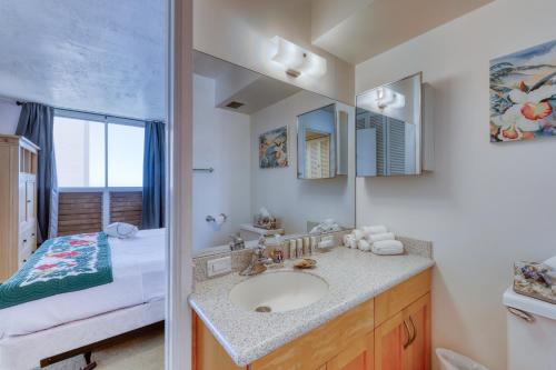 a bathroom with a sink and a bed at Harbor View Plaza #1203 in Honolulu