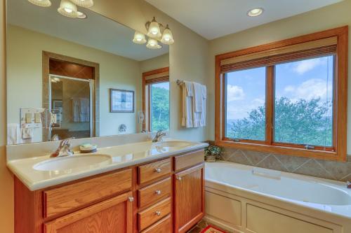 een badkamer met 2 wastafels, een bad en een raam bij Reserve 29 in Sugar Mountain