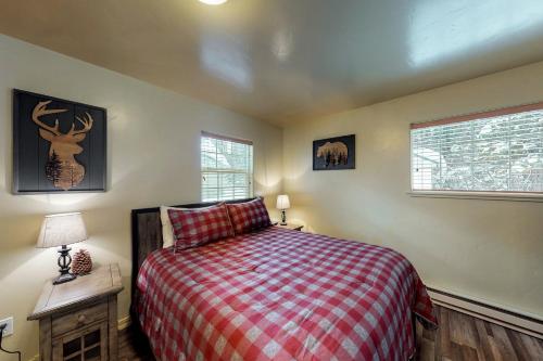 a bedroom with a bed with a red plaid blanket at Happy Trails in McCall