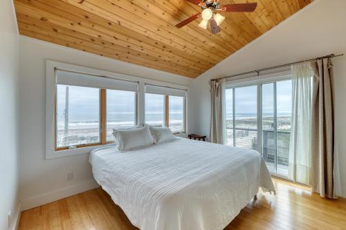 37 Ocean Bay Blvd في Ocean Bay Park: غرفة نوم مع سرير مع مروحة سقف ونوافذ