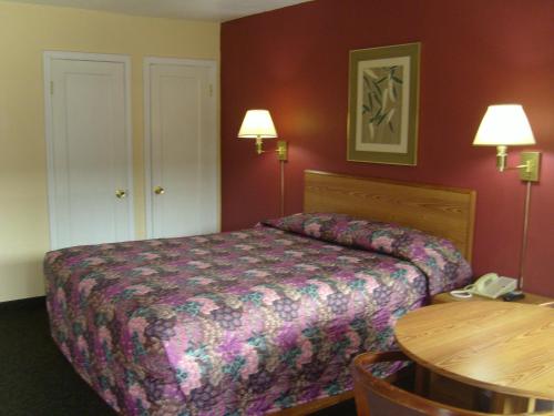 a hotel room with a bed and a table at Cascade City Center Motel in Lebanon