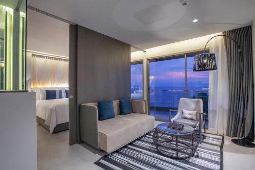 a bedroom with a bed and a chair and a table at U Jomtien Pattaya in Jomtien Beach
