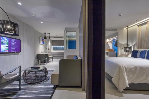 a hotel room with a large bed and a desk at U Jomtien Pattaya in Jomtien Beach