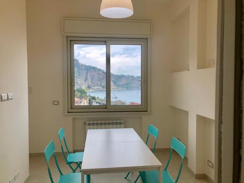 a room with a table and chairs and a window at Taormina Wonderful Solarium in Giardini Naxos