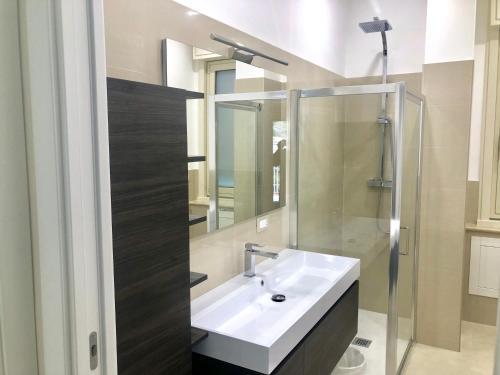 a bathroom with a white sink and a shower at Taormina Wonderful Solarium in Giardini Naxos