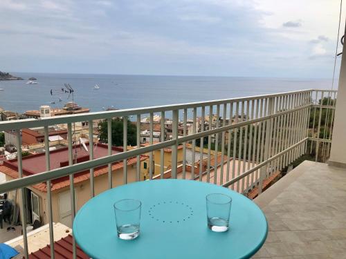 a blue table on a balcony with a view of the ocean at Taormina Wonderful Solarium in Giardini Naxos