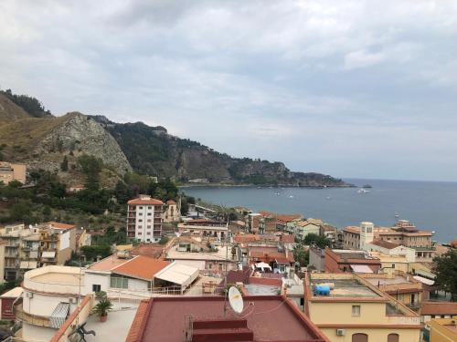 a view of a town with the ocean in the background at Taormina Wonderful Solarium in Giardini Naxos