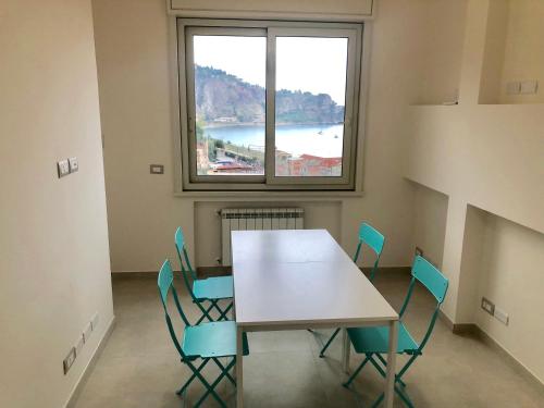 a table and chairs in a room with a large window at Taormina Wonderful Solarium in Giardini Naxos